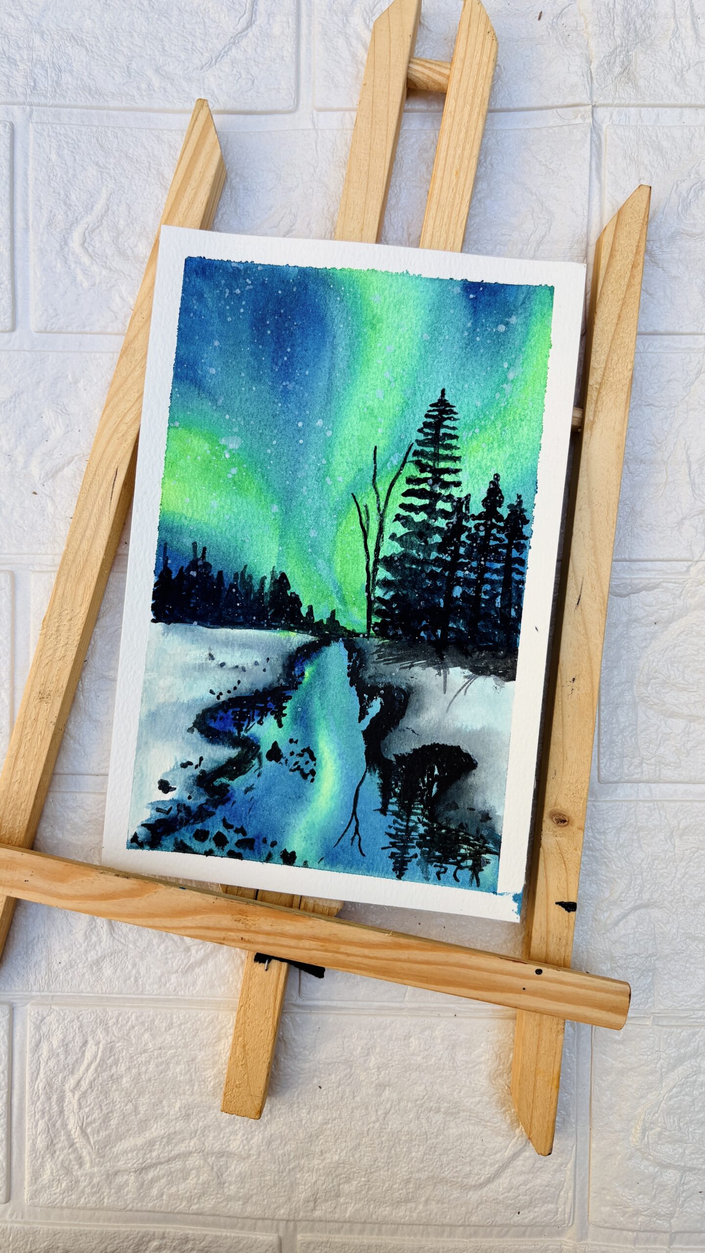Northern Lights Watercolor painting of northern lights reflecting over a river with pine trees at night